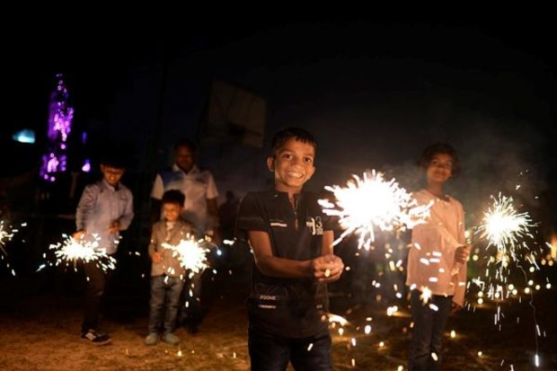 Children play with firecrackers at Madan Mohan Malviya Stadium as part of festivities celebrating Diwali festival in Prayagraj on November 10. (Image: AP)