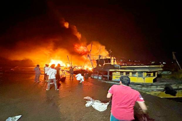 Locals at the site after a fire broke out in a jetty area, in Visakhapatnam. (PTI Photo)