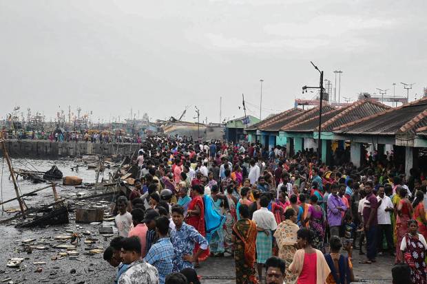 Locals at the site after firefighters extinguished the fire that broke out in a jetty area, in Visakhapatnam. (PTI Photo)