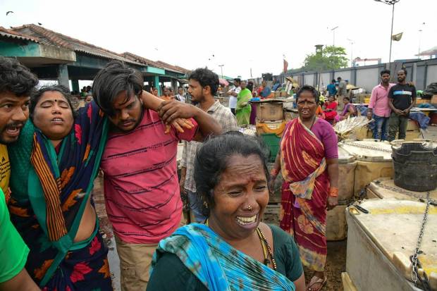 Locals at the site after firefighters extinguished the fire that broke out in a jetty area, in Visakhapatnam. (PTI Photo)