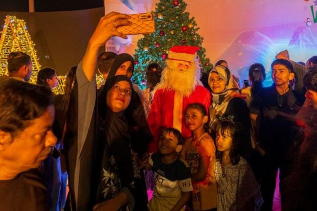 People take selfies with a man dressed as Santa Claus on the eve of Christmas in Mumbai on December 24. (AP)