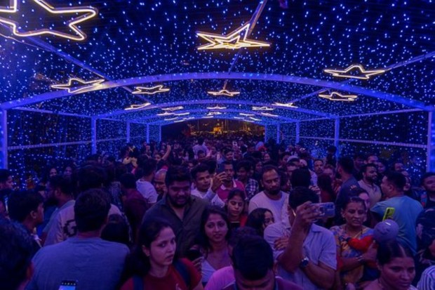 People crowd near an illuminated area of a promenade on the eve of Christmas in Mumbai. (AP)