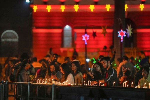 People light candles at the Sacred Heart Cathedral Church on the eve of Christmas, in New Delhi. (PTI)