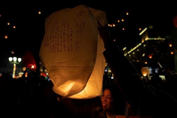 Revelers are about to release a sky lantern with wishes written on it, at Kotzia Square in central Athens, Greece. (AP)