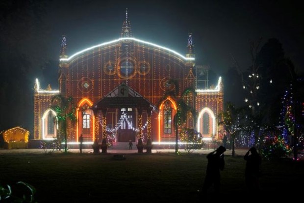 People take pictures of the decorated St. Joseph's Cathedral on the eve of Christmas in Prayagraj. (AP)