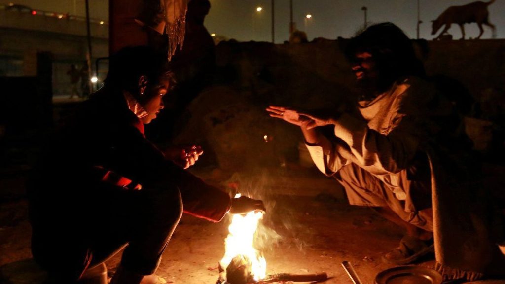 People warm themselves by a fire to escape the cold in Delhi (Image/Reuters)