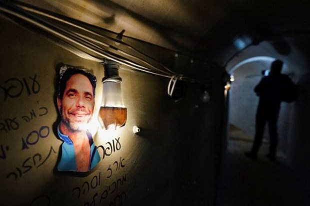 A picture, illuminated by a lightbulb, is displayed inside a tunnel set up to simulate the living conditions of the hostages kidnapped in the deadly October 7 attack by Hamas in Israel on January 13. (Image: Reuters)