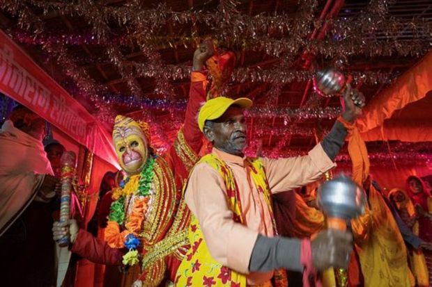 A man dressed as Lord Hanuman dances with Hindu devotees at the tent city built for the pilgrims on the banks of the Sarayu river ahead of the opening of the grand temple of Lord Ram in Ayodhya. (REUTERS)