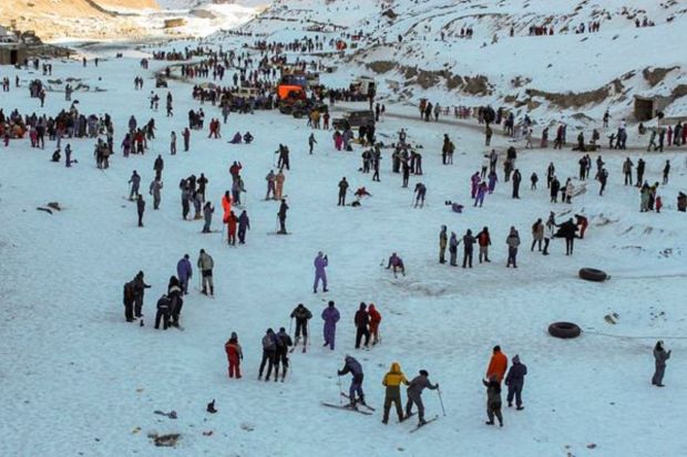 Tourists at a resort near north portal of Atal Tunnel, near Manali, Sunday. (PTI Photo)