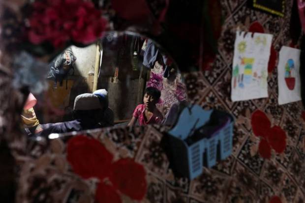 A child of a Rohingya refugee is reflected in a mirror as he eats his Iftar (breaking of fast) meal during the Muslim fasting month of Ramadan at his house in a camp in New Delhi, India. REUTERS