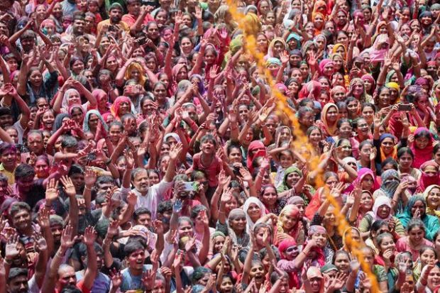 Hindu devotees pray as they are sprayed with coloured water at a temple's premises, during Holi celebrations in Ahmedabad (PTI)