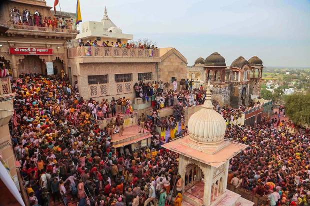 Devotees participate in Ladoo Holi celebrations at the Sriji temple in Barsana, near Mathura. (PTI Photo)