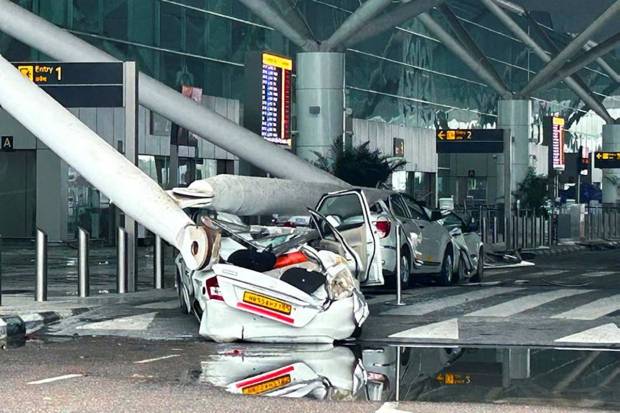 In this image, all the parked vehicles can be seen crushed by the collapse of a departure terminal canopy at Delhi Airport. (Photo source: PTI)