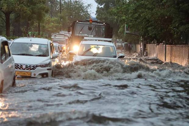 Vehicles passing through a waterlogged road amid in the National Capital. (Photo source: PTI)