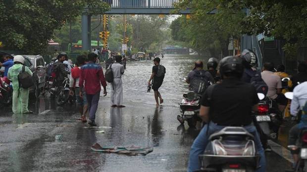 Office goers waiting because of the waterlogged road. (Photo source: PTI)