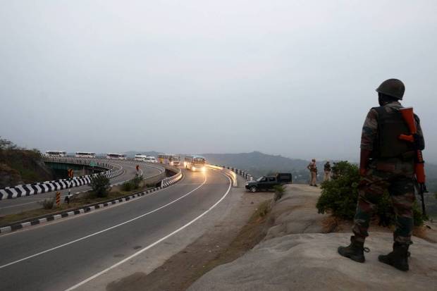 Security personnel keep a vigil as a convoy of pilgrims leave for the annual Amarnath Yatra, in Jammu. (PTI Photo)