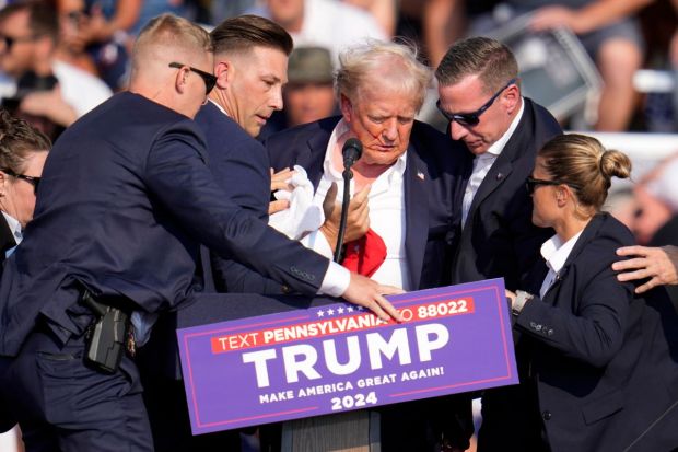 Blood drips down from former president Donald Trump's ear on his face as he is rushed off the stage(Photo: AP/PTI)