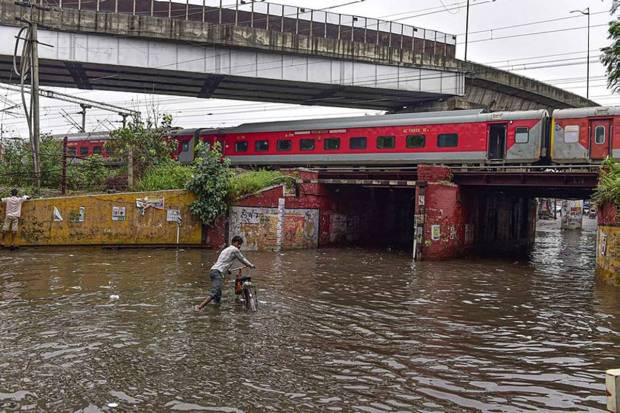 Vehicles stuck in a waterlogged road at the Old Faridabad railway underpass in Faridabad. (Photo source: PTI)