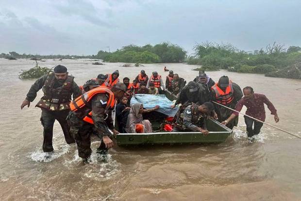 Indian Army personnel while rescuing stranded people at flood-hit areas of Jamnagar, Rajkot, and Dwarka. (Photo source: PTI)