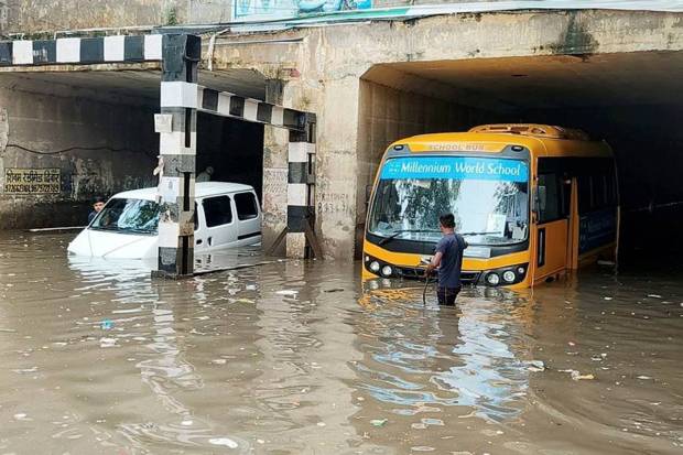 Vehicles stuck in a waterlogged road at the Old Faridabad railway underpass in Faridabad. (Photo source: PTI)