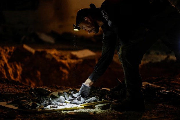 Members of the Israeli rescue force examine the site where a missile launched from Iran struck a school building in central Israel on October 1. (Reuters)