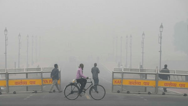 A man cycles near India Gate amid low visibility caused by smog as air quality remains in the 'severe' category. (PTI)