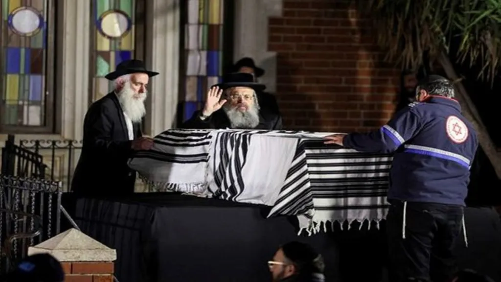 People stand next to the coffin of Israeli rabbi, Zvi Kogan, who was found murdered in the United Arab Emirates, during his funeral, in Kfar Habad, Israel, November 25, 2024. REUTERS