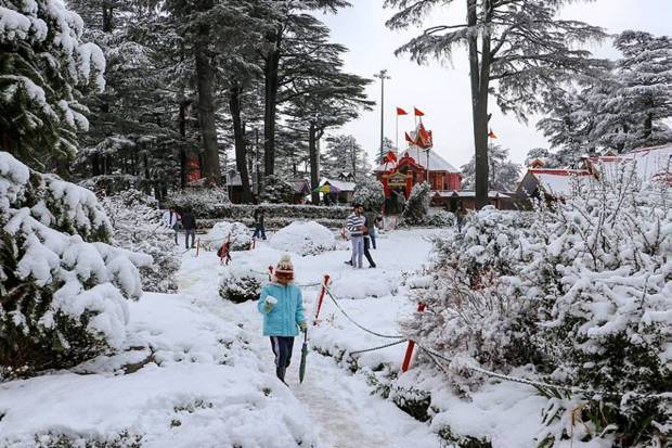 The Jakhu Temple and its premises are covered with snow after a fresh snowfall, in Shimla. Tourists can be seen visiting the temple. (Photo source: PTI)