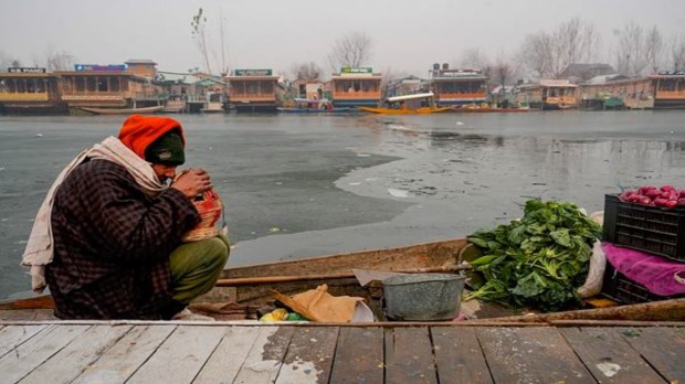 An elderly vendor braves the biting cold along the partially frozen banks of Dal Lake on a frosty morning in Srinagar, Saturday, December 21, 2024. The onset of Chillai Kalan, Kashmir's harshest 40-day winter phase, marked a historic freeze, with Srinagar recording its coldest December night in 50 years as temperatures plunged to minus 8.5 degrees Celsius, according to the meteorological department. (Photo: PTI)