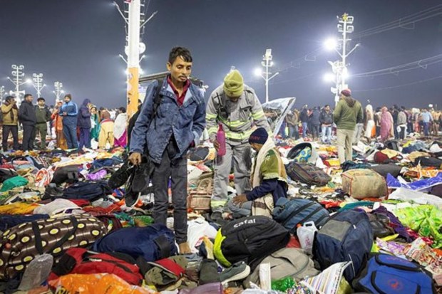 A policeman assists an injured person following a stampede before the second 