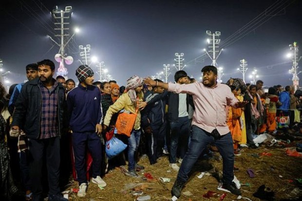 A Hindu devotee shouts as he helps clear a path for the injured following a deadly stampede before the second 