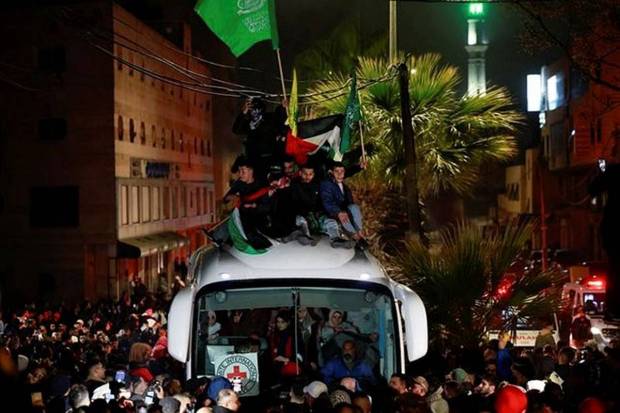 People gather around a bus carrying freed Palestinian prisoners after their release from an Israeli jail as part of a hostages-prisoners swap and a ceasefire deal in Gaza between Hamas and Israel. (Photo source: Reuters)