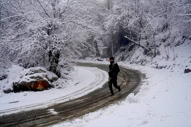 A pedestrian on a road after fresh snowfall, in Srinagar. (Photo source: PTI)