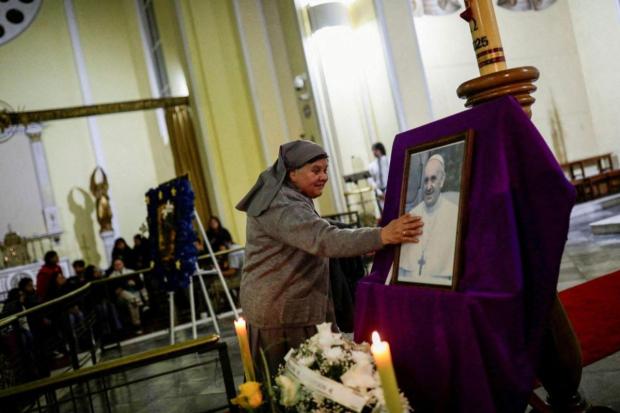 A nun touches a photograph of Pope Francis inside the Cathedral of the Most Holy Conception, following his death, in Concepcion, Chile.