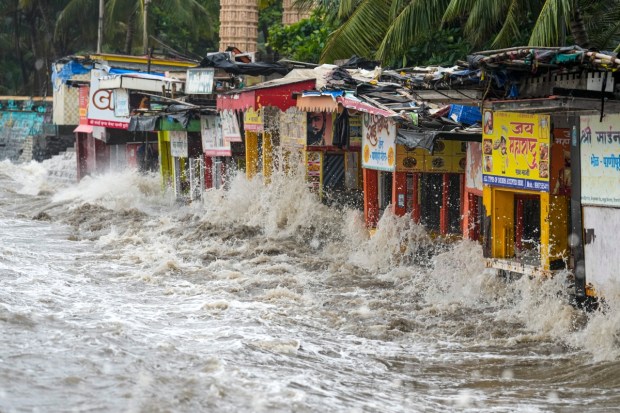 Waves hit stalls on the beach during high tide along the Arabian Sea coast in Mumbai. The city witnessed the highest tide of this monsoon season. (PTI Photo)