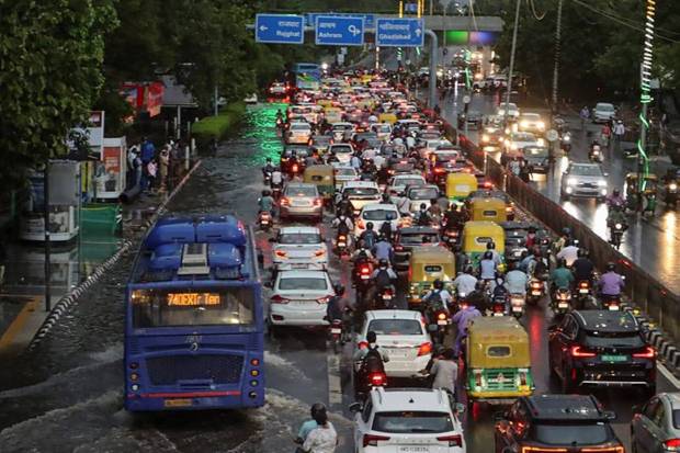Vehicles move through a waterlogged road amid traffic jam after rain at ITO, in New Delhi. The Met Department has forecast cloudy skies along with moderate rainfall in the national capital. (Photo source: PTI)