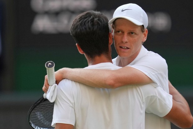 Jannik Sinner greets Carlos Alcaraz at the net after beating him to win the men's singles final at the Wimbledon Tennis Championships in London. (Photo: AP)