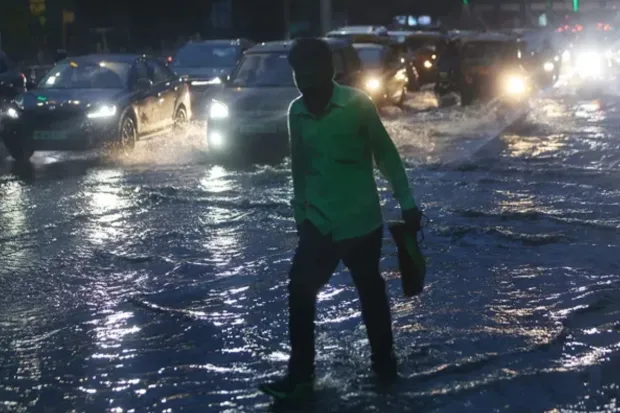 Commuters navigate flooded streets in Mumbai as torrential rains cause major traffic snarls. (Express Photo)