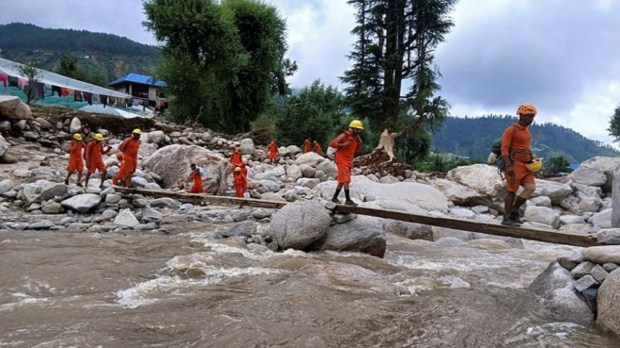 NDRF personnel walk over a makeshift bridge as the conduct relief and rescue operations in cloudburst areas of Seraj valley, in Mandi on Friday. (ANI Photo)