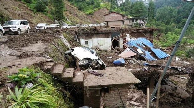 A view of the damaged car and houses following cloudburst, in Mandi on Saturday. (ANI Photo)