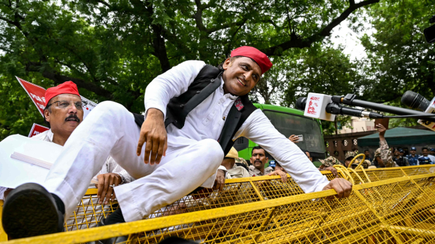  Following his claims alleging the BJP of electoral manipulation, Yadav physically climbed the police barricades during the protest on Parliament Street on Monday, saying the BJP is using police to stop us from peacefully protesting. (Photo Source: Official Twitter handle @INCIndia)