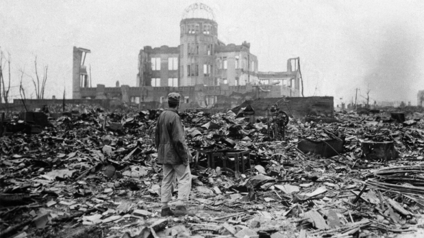 In this September 8, 1945, file photo, an Allied correspondent stands in a sea of rubble before the shell of a building that once was a cinema in Hiroshima, western Japan, a month after the first atomic bomb ever used in warfare was dropped by the US to hasten Japan’s surrender. Many people exposed to radiation developed symptoms such as vomiting and hair loss. Most of those with severe radiation symptoms died within three to six weeks. Others who lived beyond that developed health problems related to burns, radiation-induced cancers and other illnesses. (Photo Source: Associated Press)