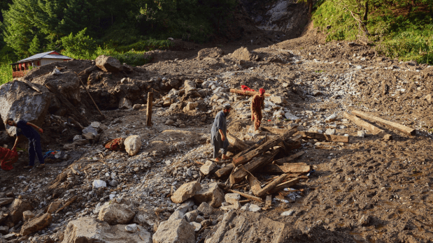 Villagers collect wood and other useful items from the debris of damaged houses at the incident site of a cloudburst that triggered a flash flood, in Naryan Behak village near Muzaffarabad in Pakistan. (Photo Source: Associated Press)