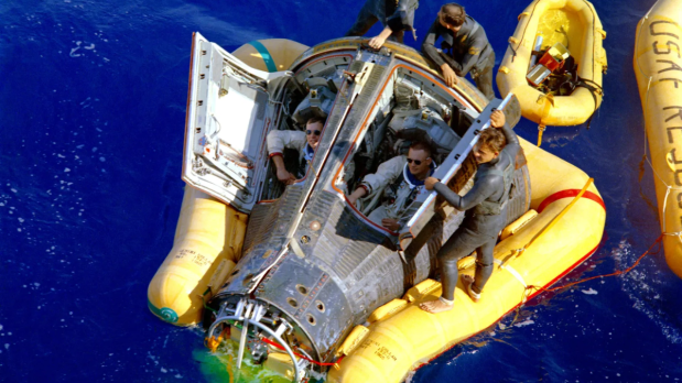 After docking, a rocket thruster malfunction sent the spacecraft into an uncontrolled spin and forced them to separate the gemini craft from the Agena. Armstrong then regained control of the Gemini craft and made an emergency splashdown in the Pacific Ocean. (In Picture: Gemini VIII astronauts Neil Armstrong and David Scott sit in their spacecraft while waiting for the arrival of the recovery ship, the USS Leonard Mason. They are assisted by three U.S. Air Force pararescue divers.) (Photo Source: NASA)