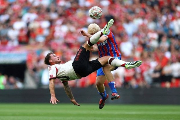 Alexis Mac Allister of Liverpool kicking the ball for goal against Will Hughes of Crystal Palace. (Image Source: Reuters)