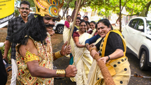 A person dressed as King Mahabali looks on as people compete in 'Tug of War' as part of Onam festival celebrations organised by the Forest Department, in Kozhikode, Wednesday, Sept. 3, 2025 (Photo Source: PTI)