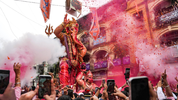 People take part in a procession for immersion of 'Mumbai Cha Raja' idol of Lord Ganesha as part of the Ganesh Chaturthi festival celebrations, in Mumbai on Saturday.