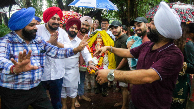 People dance as they arrive to immerse an idol of Lord Ganesha into a canal during the Ganesh Chaturthi festival celebrations, in Amritsar.